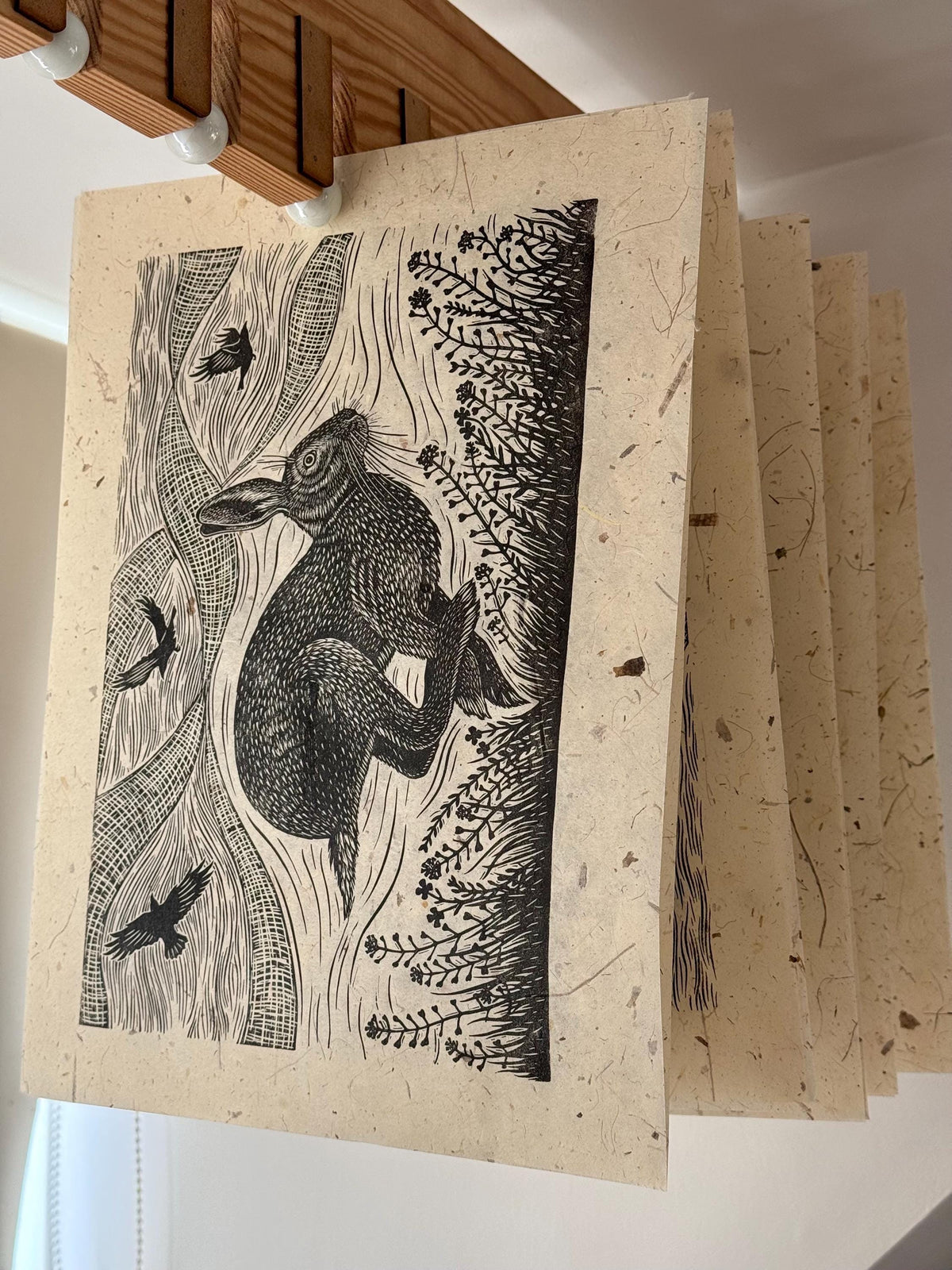 Linocut print of hare and crows